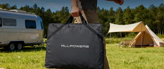 Housse de transport du panneau ALLPOWERS SE200 portée à la main devant des tentes de camping
