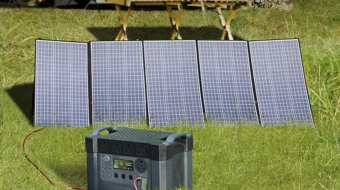 Panneau solaire ALLPOWERS SP037 400W déplié dans l'herbe, relié à une station électrique portable