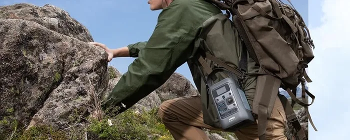 Anker SOLIX C300 accrochée à un sac à dos lors d'une randonnée en montagne