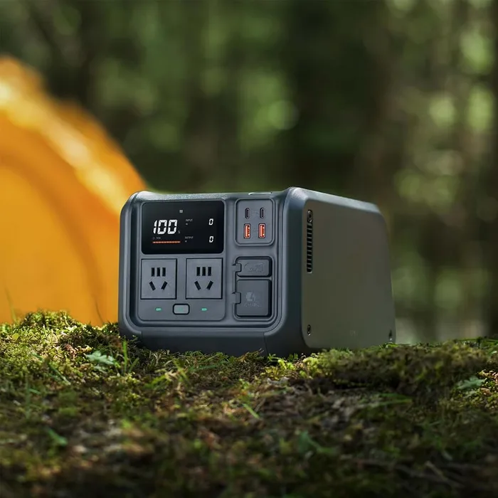 DJI Power 500 posée sur un tapis de mousse en sous-bois, une tente orange en arrière-plan