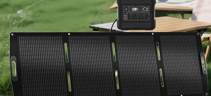 Panneau solaire ECO-WORTHY 200W déplié dans l'herbe, relié à une station électrique posée sur une table