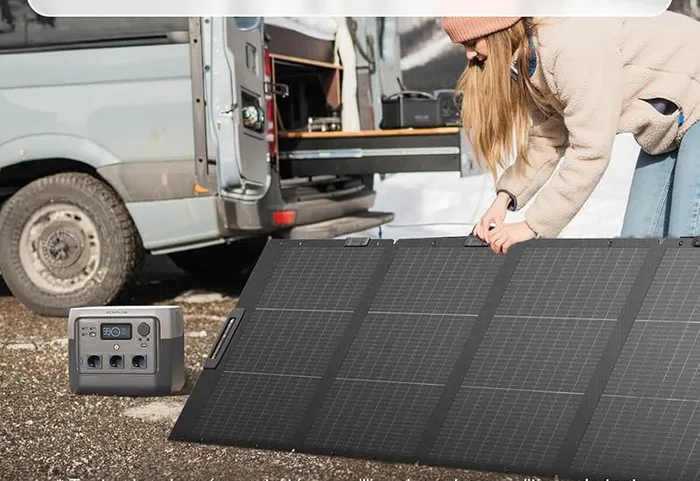 EcoFlow DELTA 2 reliée à un panneau solaire déplié à côté d'un van aménagé