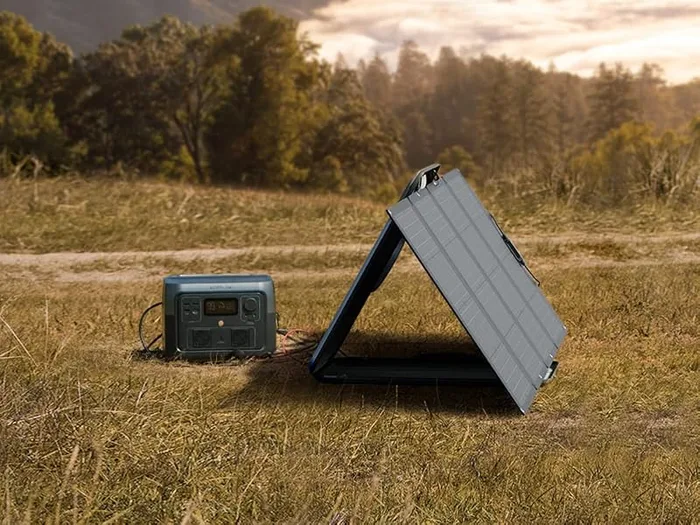 Panneau solaire EcoFlow 160 W déplié dans un pré au soleil couchant, relié à une station River 2 Max
