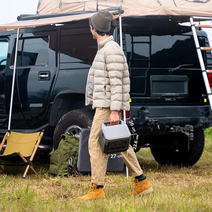 EcoFlow River 2 Pro transportée à la main devant un pick-up équipé d'une tente de toit