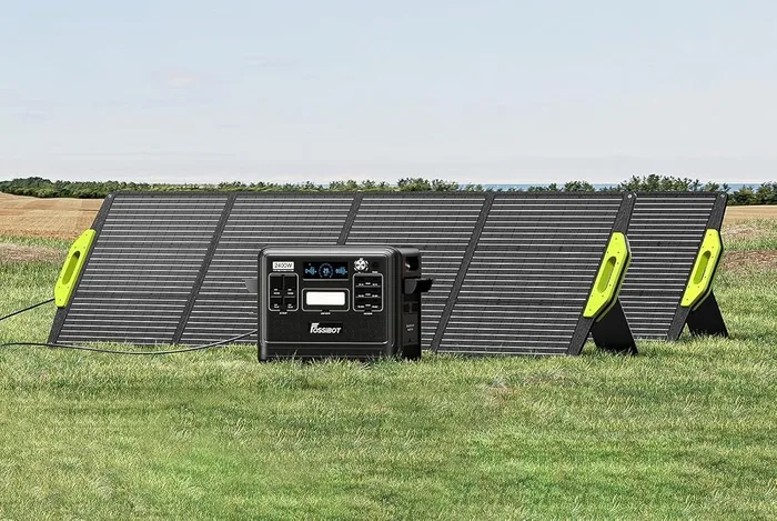 Panneau solaire FOSSiBOT SP200 déplié sur ses béquilles dans un pré, relié à une station électrique