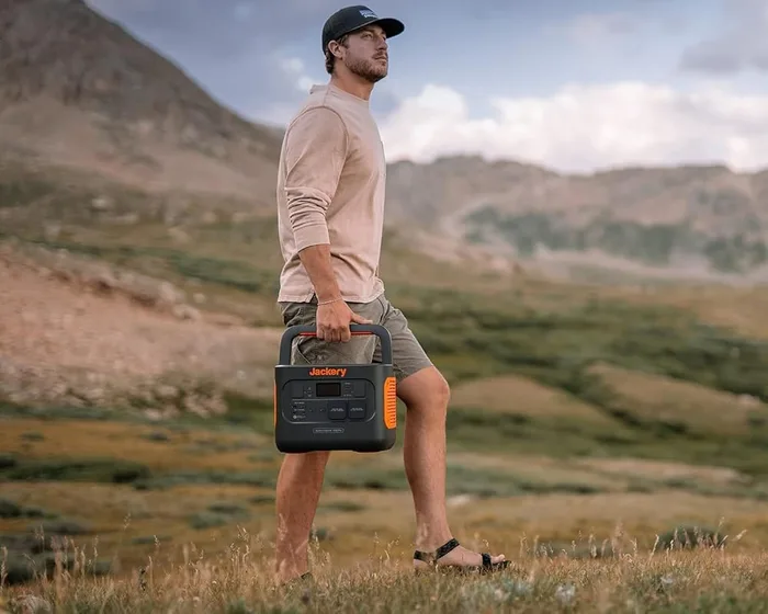 Jackery Solar Generator 1000 Pro transporté à bout de bras dans un paysage de montagne