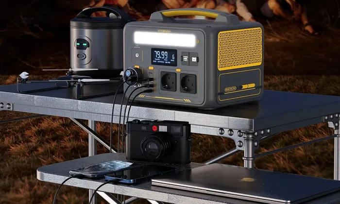 VTOMAN Jump 600X sur une table de camp de nuit, reliée à plusieurs appareils